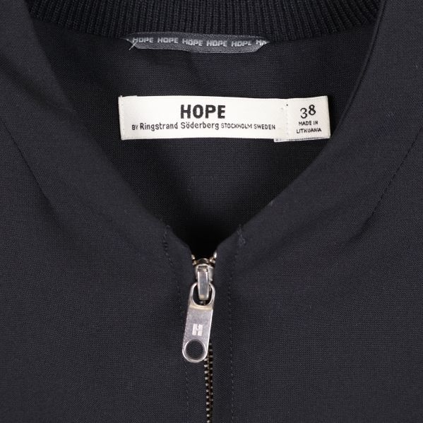Närbild på etikett och krage med Hope-logotyp