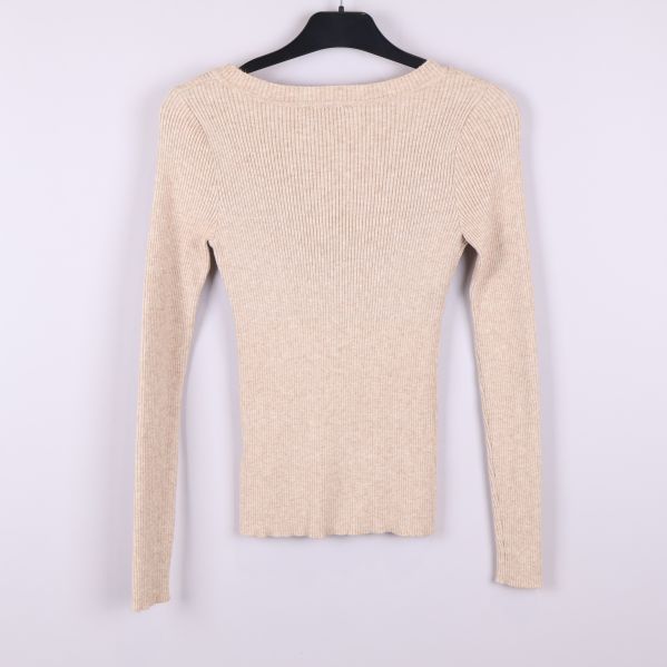 Beige ribbstickad långärmad tröja bakifrån