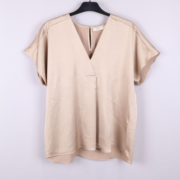 Framsida på beige kortärmad blus med v-ringning