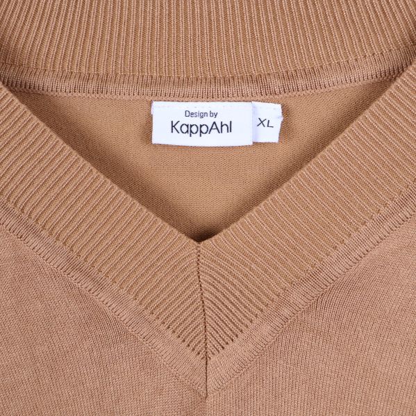 Närbild på v-ringad hals och märkning Design by KappAhl