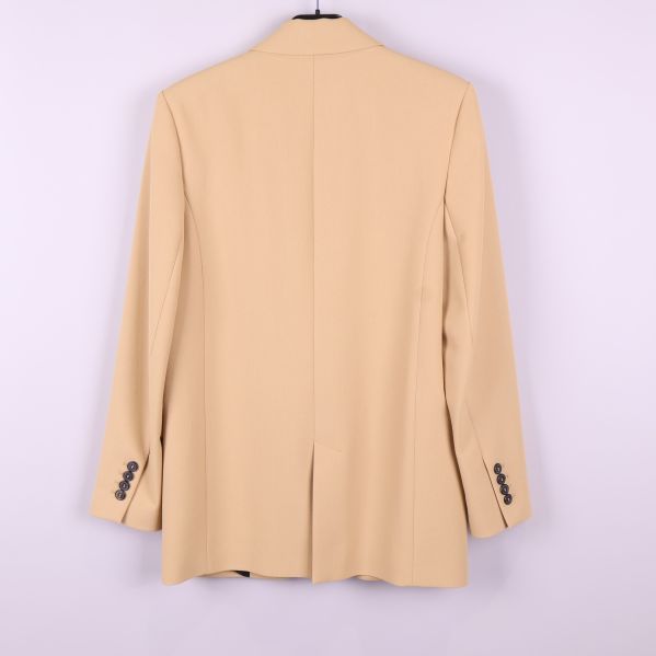 Baksidan av beige kavaj med slits