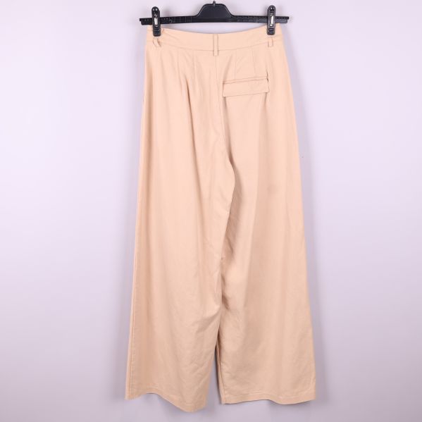 Baksida av beige vida byxor med ficka