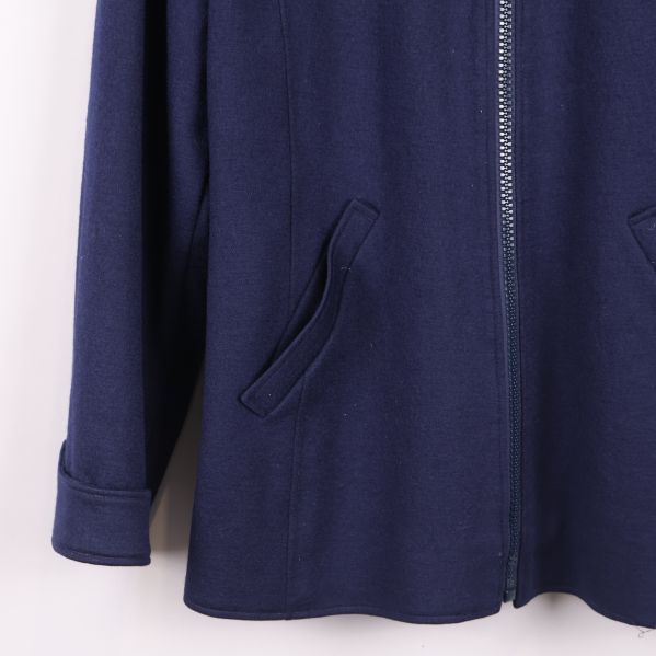 Närbild på ficka och nederkant av blå jacka