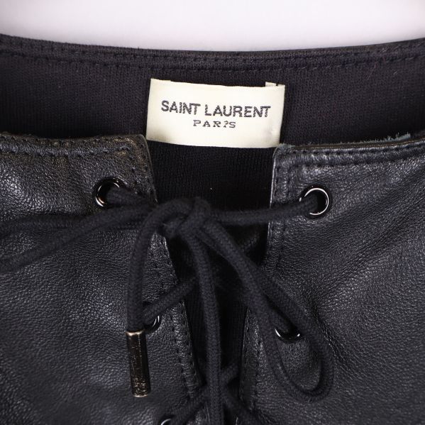 Närbild på etikett från Saint Laurent Paris vid snörningen