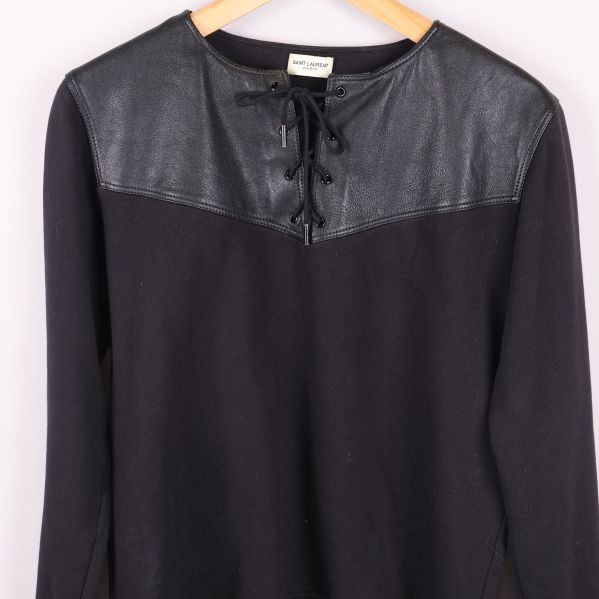 Närbild på överdelen av sweatshirten med läder och snörning