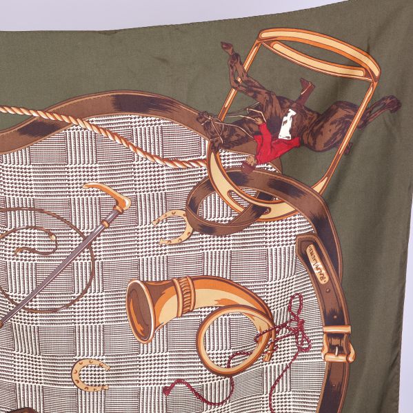 Närbild på scarf med horn, stol och hästtema