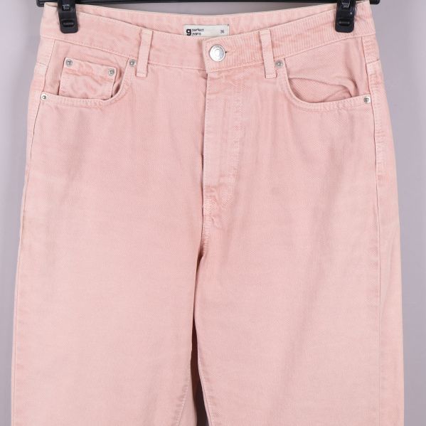 Närbild på benslut och fickor fram på ljusrosa jeans