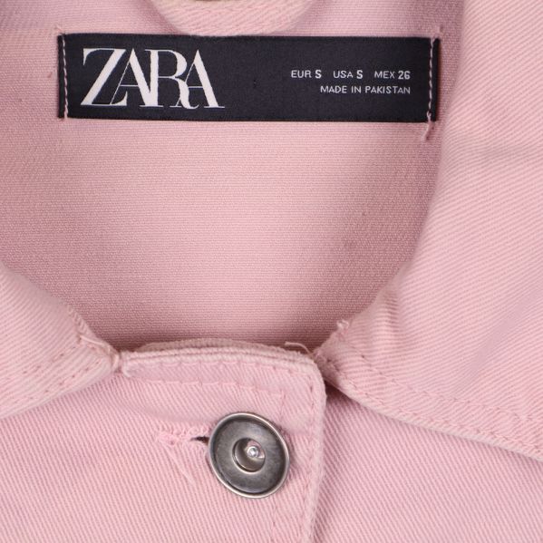 Närbild på ZARA-märket och jackkragen