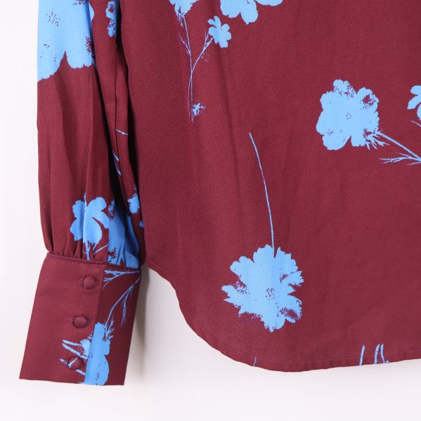 Närbild på manschett med knappar och blommönster