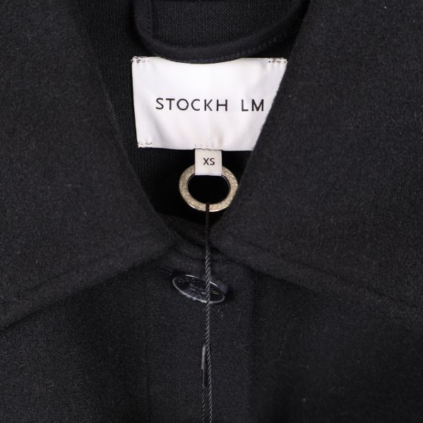 Närbild på krage och varumärkesetikett STOCKH LM