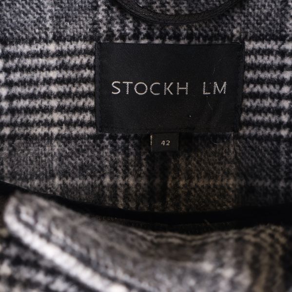 Närbild på etikett med texten STOCKH LM och storlek 42