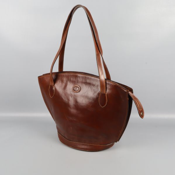 Brun läderväska i vinkel med långa axelremmar