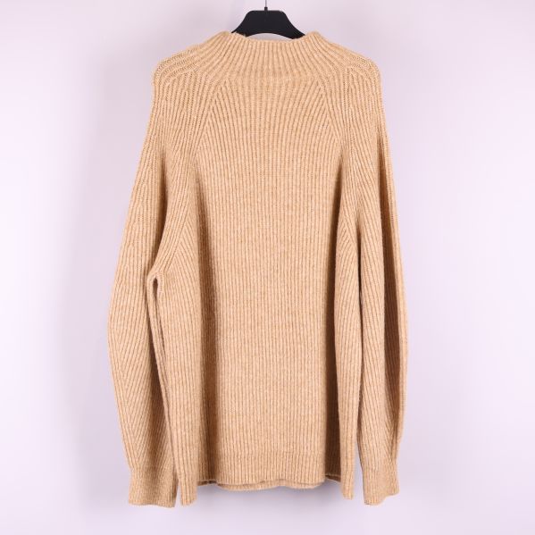 Baksida på beige stickad tröja 