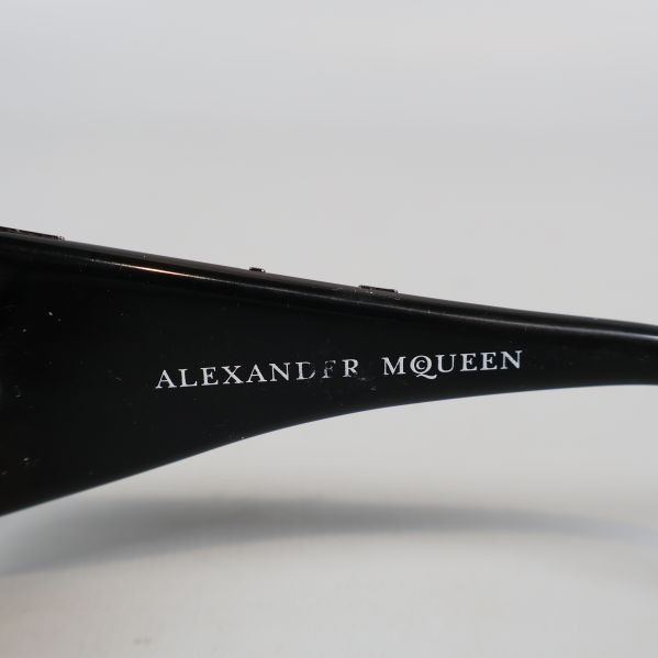 Närbild på Alexander McQueen logotyp på skalmen