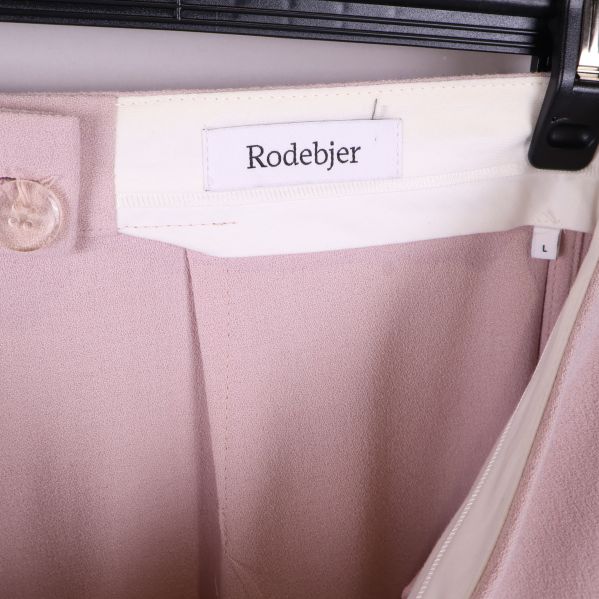 Närbild av Rodebjer-etikett i midjan på byxorna