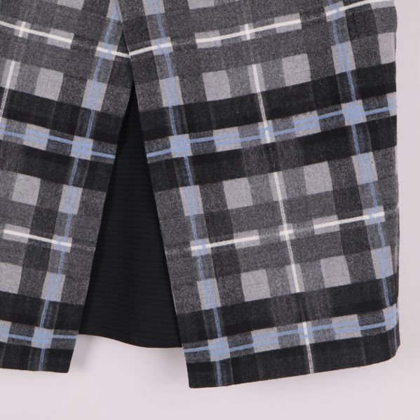 Närbild på slitsen framtill i rutmönstrad kjol