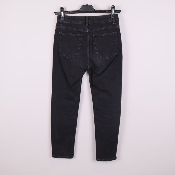 Baksida av svarta jeans med bakfickor synliga