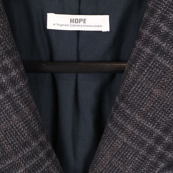 Närbild på HOPE-logga i kappans krage