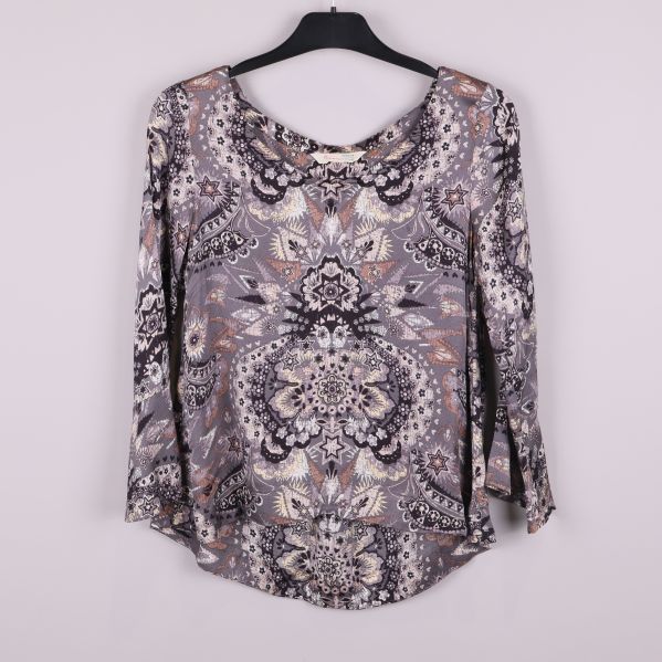 Topp med grafiskt mönster och utsvängda ärmar framifrån