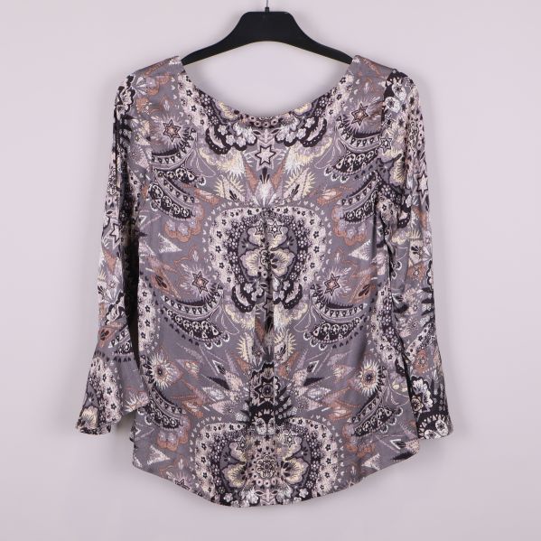 Topp med grafiskt mönster och utsvängda ärmar bakifrån