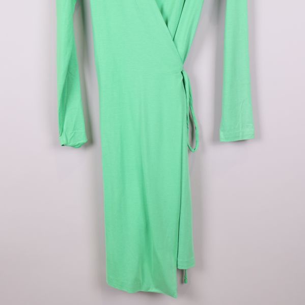 Nedre del av grön omlottklänning med knytband