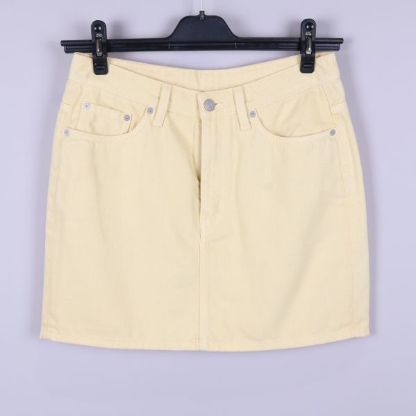 Ljusgul kjol framifrån med fem fickor och knapp