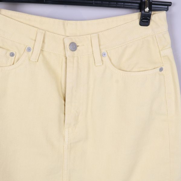 Närbild på midjeband, fickor och knapp framtill på kjolen