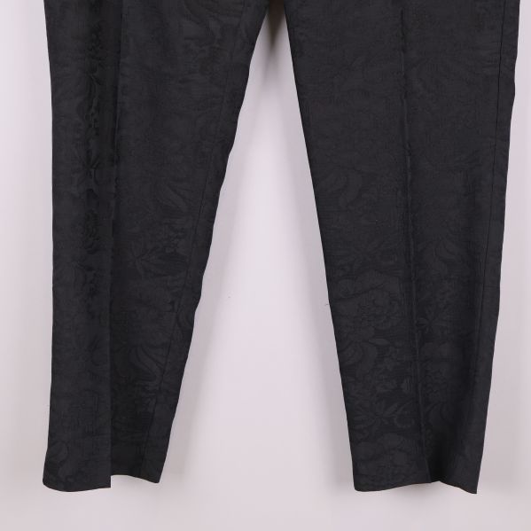 Närbild på benen av svarta byxor med struktur