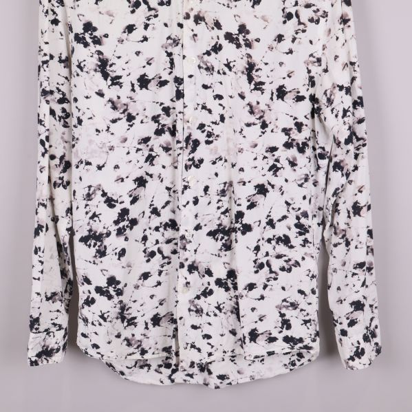 Närbild på skjortans framtill med knappar och mönster