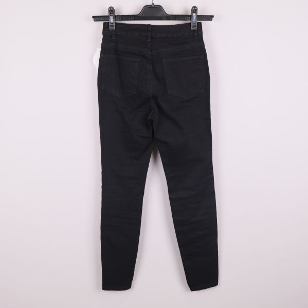 Baksida av svarta skinnyjeans med fickor