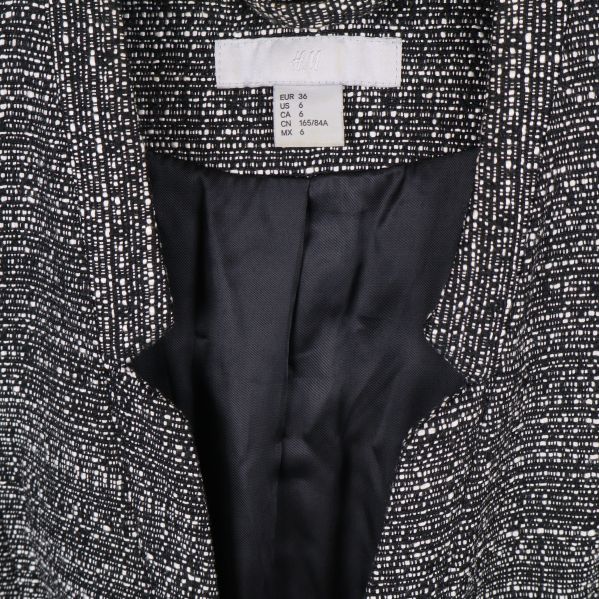 Närbild på kavajens etikett och storleksinformation vid kragen