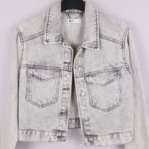 Närbild på framsidan av ljus acid wash jeansjacka