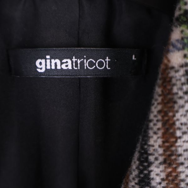 Närbild på gina tricot etikett i jacka