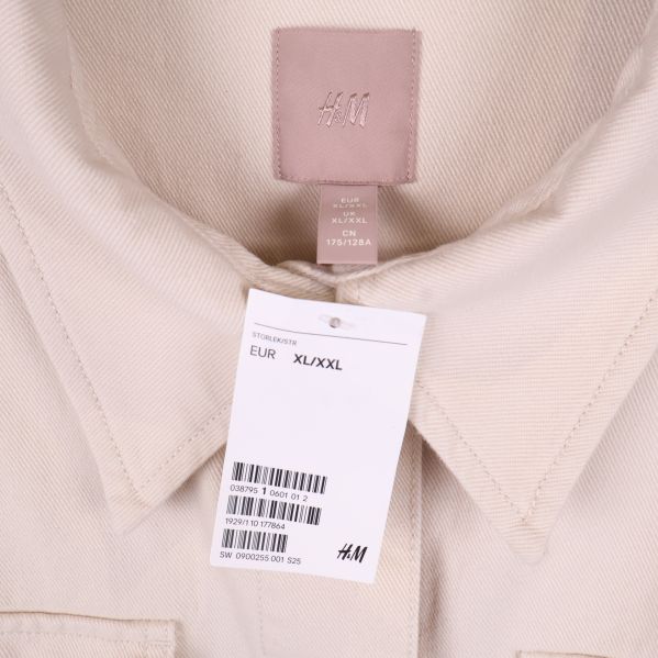 Kragdetalj och etikett på beige overshirt från H&M