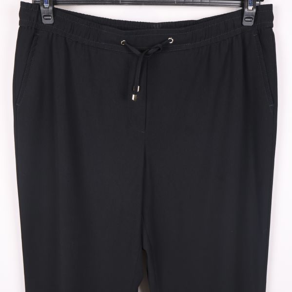 Närbild på byxors midja med dragsko och fickor