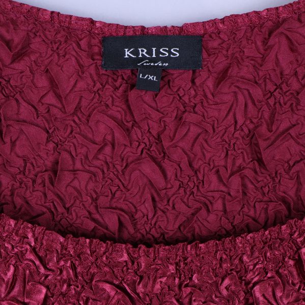 Närbild på kriss-märke och stretchig krage i rött tyg