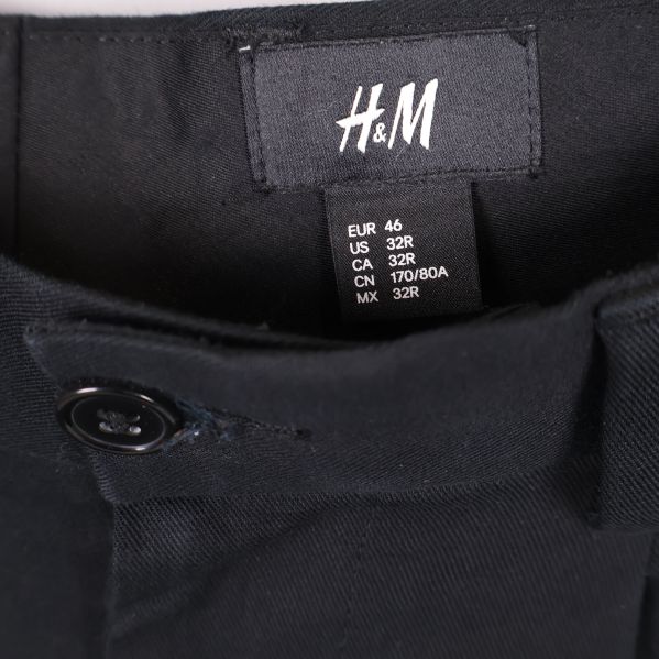 Närbild på H&M-etikett och storlekslapp i byxorna