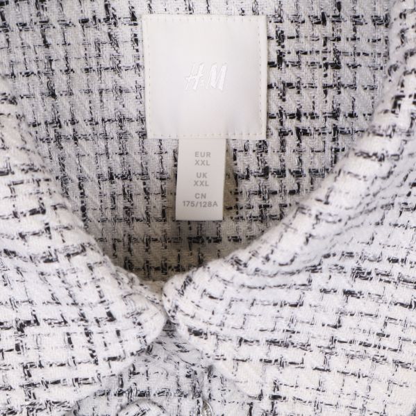 Närbild på etikett som visar H&M och storlek XXL