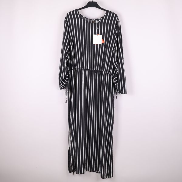 Lång svartvit randig klänning framifrån på galge