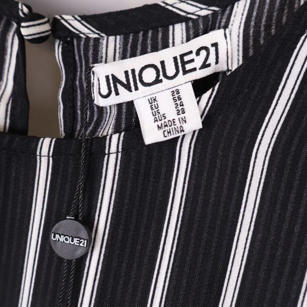 Närbild på etikett UNIQUE21 och knapp i nacken