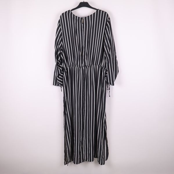 Lång svartvit randig klänning bakifrån på galge