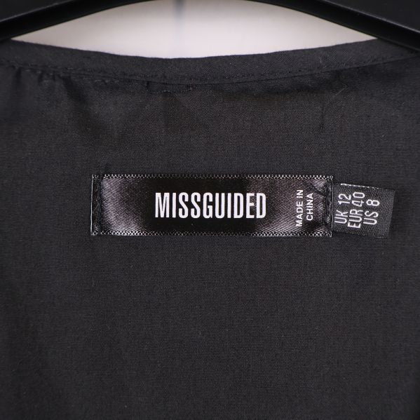 Närbild på Missguided-logotyp och storlekslapp inuti klänningen