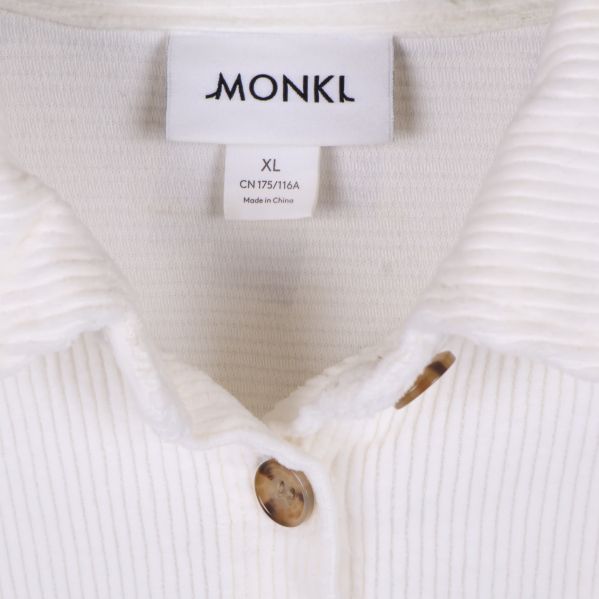 Närbild på Monki-etikett och vit krage