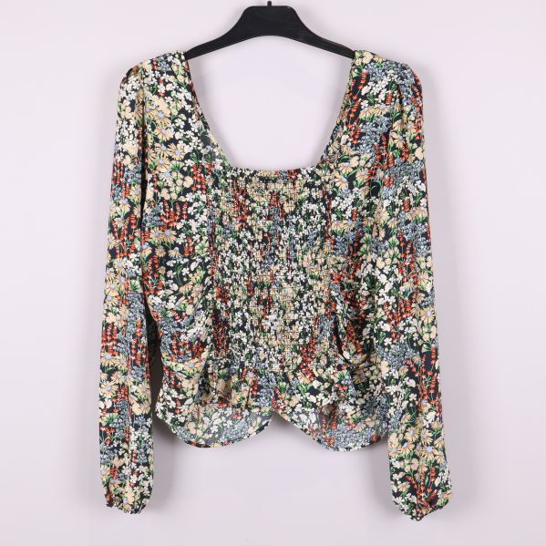 Baksida på blommig blus med smock och långa ärmar