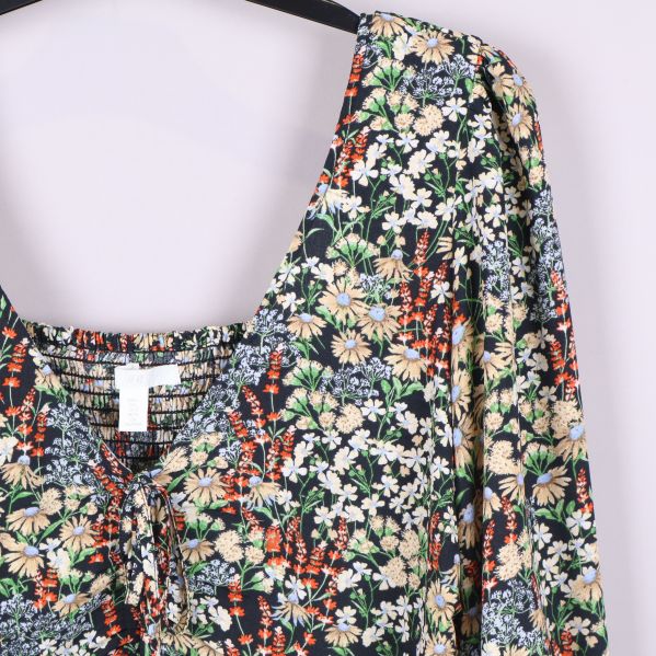 Axelparti och smockdetalj på blommig blus