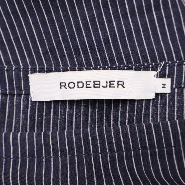 Närbild på Rodebjer-märke i halsen på randig blus