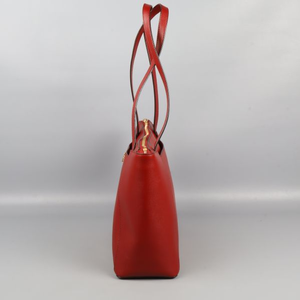 Smal sida av röd axelväska med långa handtag