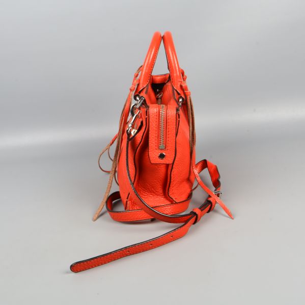 Röd väska med närbild på dragkedjedetalj