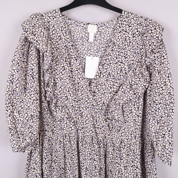 Överdel av klänningen med v-ringning och volang