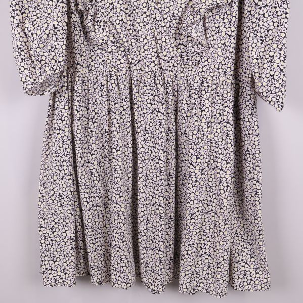 Nederdel av blommig klänning med volanger framtill